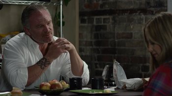 Movie still from “Do You Believe?” (2015), directed by Jon Gunn – A man sitting at a table with an open umbrella; Close Up shot, Over the shoulder angle