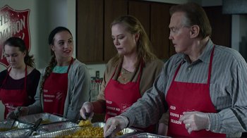 Movie still from “Do You Believe?” (2015), directed by Jon Gunn – A group of people standing in a kitchen preparing food; Medium shot, Over the shoulder angle