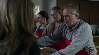 Movie still from “Do You Believe?” (2015), directed by Jon Gunn – A group of people sitting around a table with food on it; Medium shot, Over the shoulder angle