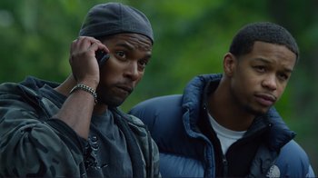 Movie still from “Do You Believe?” (2015), directed by Jon Gunn – A man talking on a cell phone next to another man; Close Up shot, Over the shoulder angle