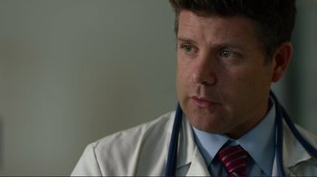 Movie still from “Do You Believe?” (2015), directed by Jon Gunn – A male doctor wearing a white lab coat and a red striped tie; Close Up shot, Low angle