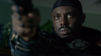 Movie still from “Do You Believe?” (2015), directed by Jon Gunn – A person holding a gun; Close Up shot, Low angle