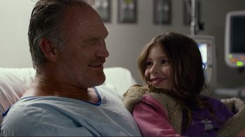 Movie still from “Do You Believe?” (2015), directed by Jon Gunn – A man and a little girl sitting next to each other; Close Up shot, Over the shoulder angle