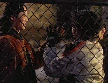 Movie still from “Doctor Who: The Movie” (1996), directed by Geoffrey Sax – Two people are standing in a fenced in area; Medium shot, Over the shoulder angle