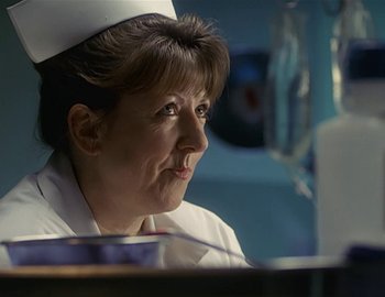 Movie still from “Doctor Who: The Movie” (1996), directed by Geoffrey Sax – A woman wearing a nurse's hat looking off into the distance; Close Up shot, Low angle