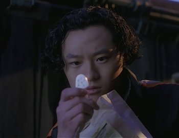 Movie still from “Doctor Who: The Movie” (1996), directed by Geoffrey Sax – A man holding a piece of paper in his hand; Close Up shot, High angle