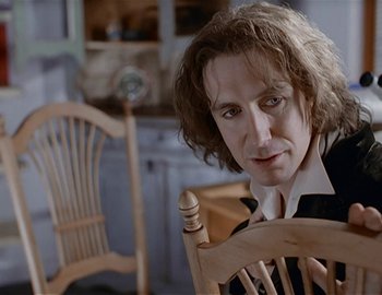 Movie still from “Doctor Who: The Movie” (1996), directed by Geoffrey Sax – A man sitting in a chair in front of a window; Close Up shot, Over the shoulder angle