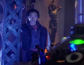 Movie still from “Doctor Who: The Movie” (1996), directed by Geoffrey Sax – A man standing next to a wooden fence; Medium shot, Over the shoulder angle