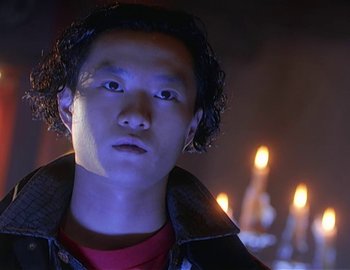 Movie still from “Doctor Who: The Movie” (1996), directed by Geoffrey Sax – A young man in a dark room with lit candles in the background; Close Up shot, Low angle