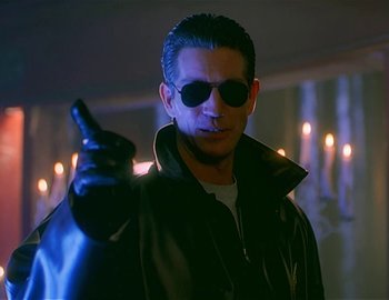 Movie still from “Doctor Who: The Movie” (1996), directed by Geoffrey Sax – A man wearing sunglasses and a leather jacket holding a cell phone; Close Up shot, Low angle