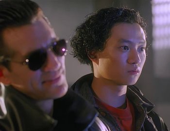 Movie still from “Doctor Who: The Movie” (1996), directed by Geoffrey Sax – A man and a woman wearing sunglasses and looking into the distance; Close Up shot, Low angle