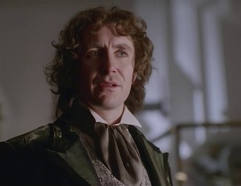 Movie still from “Doctor Who: The Movie” (1996), directed by Geoffrey Sax – A person with curly hair wearing a suit; Close Up shot, Over the shoulder angle