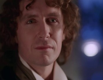 Movie still from “Doctor Who: The Movie” (1996), directed by Geoffrey Sax – A person with curly brown hair; Close Up shot, Over the shoulder angle