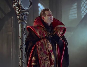 Movie still from “Doctor Who: The Movie” (1996), directed by Geoffrey Sax – A man dressed as a vampire standing next to a pole; Medium shot, Low angle