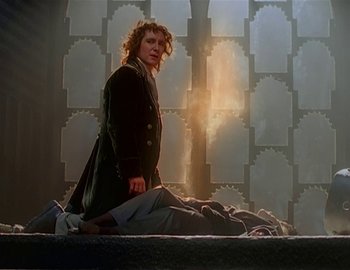Movie still from “Doctor Who: The Movie” (1996), directed by Geoffrey Sax – A man standing over a dead body in a room; Medium shot, Low angle