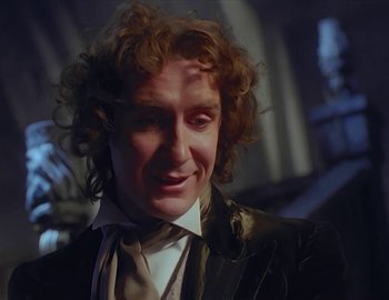 Movie still from “Doctor Who: The Movie” (1996), directed by Geoffrey Sax – A person with curly hair wearing a suit; Close Up shot, Over the shoulder angle