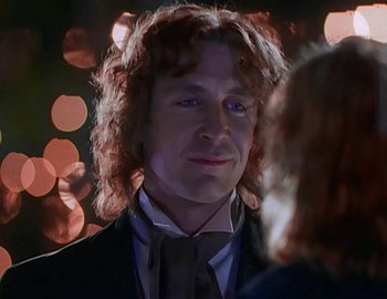 Movie still from “Doctor Who: The Movie” (1996), directed by Geoffrey Sax – A person with curly hair wearing a suit; Close Up shot, Over the shoulder angle