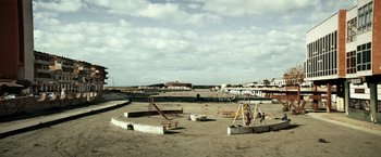 Movie still from “Dogman” (2018), directed by Matteo Garrone – An empty playground in the middle of a sandy beach; Extreme Wide shot, High angle