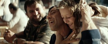 Movie still from “Dogman” (2018), directed by Matteo Garrone – A man and a little girl are smiling for the camera; Close Up shot, Over the shoulder angle