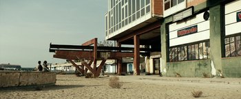 Movie still from “Dogman” (2018), directed by Matteo Garrone – An abandoned building on the beach in the sand; Extreme Wide shot, Low angle