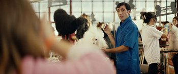 Movie still from “Dogman” (2018), directed by Matteo Garrone – A man standing in front of a white fluffy dog; Medium shot, Over the shoulder angle