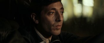 Movie still from “Dogman” (2018), directed by Matteo Garrone – A person wearing a suit and tie; Close Up shot, Low angle