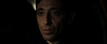 Movie still from “Dogman” (2018), directed by Matteo Garrone – A person wearing a suit and tie; Close Up shot, Low angle