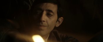 Movie still from “Dogman” (2018), directed by Matteo Garrone – A man's face with a light shining on him; Close Up shot, Over the shoulder angle