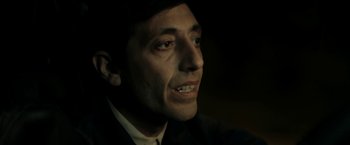 Movie still from “Dogman” (2018), directed by Matteo Garrone – A person wearing a suit and tie; Close Up shot, Over the shoulder angle