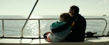 Movie still from “Dogman” (2018), directed by Matteo Garrone – A man and a woman sitting on the back of a sailboat; Wide shot, Over the shoulder angle