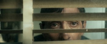 Movie still from “Dogman” (2018), directed by Matteo Garrone – A man peeking through a window blinds; Extreme Close Up shot, Low angle