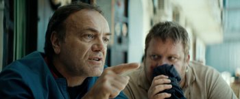 Movie still from “Dogman” (2018), directed by Matteo Garrone – A man pointing at another man holding a cell phone; Close Up shot, Over the shoulder angle