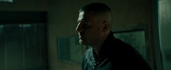 Movie still from “Dogman” (2018), directed by Matteo Garrone – A person wearing a black jacket; Close Up shot, Low angle