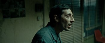 Movie still from “Dogman” (2018), directed by Matteo Garrone – A person wearing a black shirt; Close Up shot, Low angle