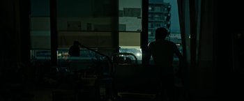 Movie still from “Dogman” (2018), directed by Matteo Garrone – A person sitting in a room looking out of a window; Wide shot, Over the shoulder angle