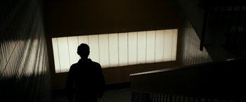 Movie still from “Dogman” (2018), directed by Matteo Garrone – A man standing in front of a window with light coming through; Medium shot, Low angle