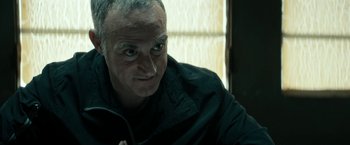 Movie still from “Dogman” (2018), directed by Matteo Garrone – A person wearing a black jacket; Close Up shot, Low angle