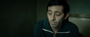 Movie still from “Dogman” (2018), directed by Matteo Garrone – A person with his eyes closed; Close Up shot, High angle