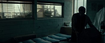 Movie still from “Dogman” (2018), directed by Matteo Garrone – A person standing in front of a window in a room; Medium shot, Over the shoulder angle