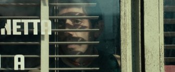 Movie still from “Dogman” (2018), directed by Matteo Garrone – A man looking out of a window through bars; Close Up shot, Over the shoulder angle