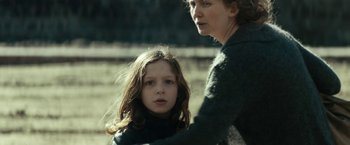 Movie still from “Dogman” (2018), directed by Matteo Garrone – A woman and a young girl standing next to each other; Medium shot, Over the shoulder angle