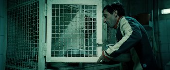 Movie still from “Dogman” (2018), directed by Matteo Garrone – A man looking out of a jail cell window; Medium shot, High angle