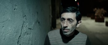 Movie still from “Dogman” (2018), directed by Matteo Garrone – A person wearing a sweater; Close Up shot, Over the shoulder angle