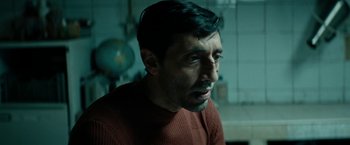 Movie still from “Dogman” (2018), directed by Matteo Garrone – A person wearing a red shirt; Close Up shot, Low angle