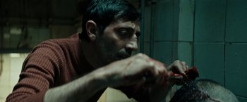 Movie still from “Dogman” (2018), directed by Matteo Garrone – A person with blood on his face; Close Up shot, Over the shoulder angle