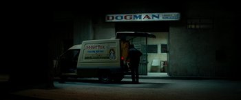 Movie still from “Dogman” (2018), directed by Matteo Garrone – A man standing next to a dog sitter van; Wide shot, Over the shoulder angle