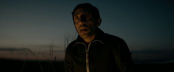 Movie still from “Dogman” (2018), directed by Matteo Garrone – A man in a black jacket is standing in the dark; Close Up shot, Low angle
