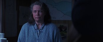 Movie still from “Dolores Claiborne” (1995), directed by Taylor Hackford – An older woman is standing in front of a map; Close Up shot, Over the shoulder angle