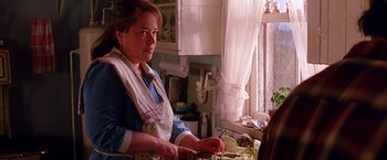 Movie still from “Dolores Claiborne” (1995), directed by Taylor Hackford – A woman in an apron standing at a kitchen sink; Close Up shot, Over the shoulder angle