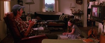 Movie still from “Dolores Claiborne” (1995), directed by Taylor Hackford – A girl sitting on the ground in a living room; Medium shot, Over the shoulder angle